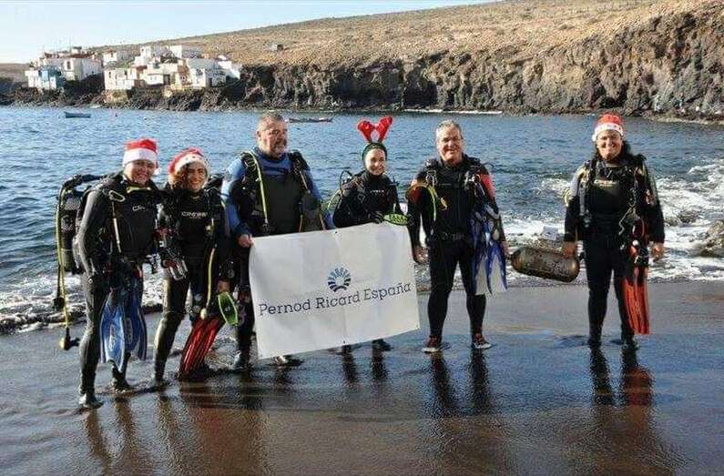 Miembros del Club de Buceo Gran Azul posan en la orilla de la playa de Tufia con la botella que contiene el pequeño nacimiento (Foto TA)