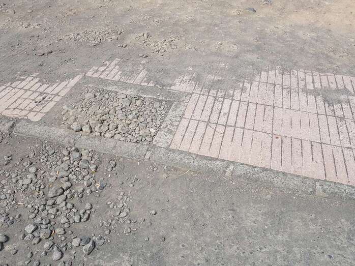 Los conductores tienen que atravesar el bordillo de una acera para acceder al solar (Foto TA)