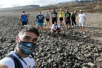 Un grupo de jóvenes limpia la playa de Jinámar/TA.