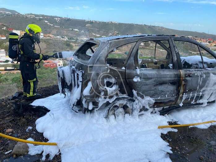 Bombero en acción para sofocar las llamas del vehículo/TA.