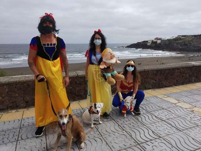 Familia desfrazada paseado con sus mascotas por el paseo marítimo de Playa del Hombre/TA.
