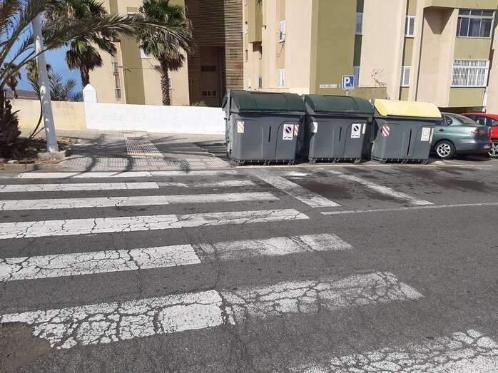 Los contenedores impiden a los peatones observar a los coches que circulan por la vía / TA