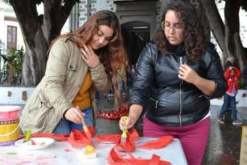 Dos jóvenes pintan sus zapatos de rojo el pasado domingo en Valsequillo (Foto TA)