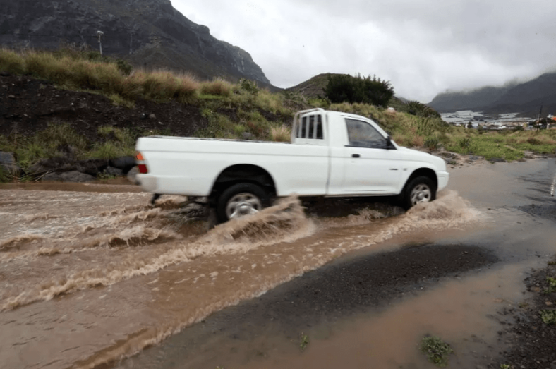 Un vehículo atraviesa una carretera inundada por las lluvias en el municipio de La Aldea de San Nicolás (Foto Efe / Elvira Urquijo)