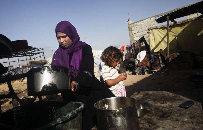 Una mujer lava unas las ollas en la Franja de Gaza (Foto Canarias7)