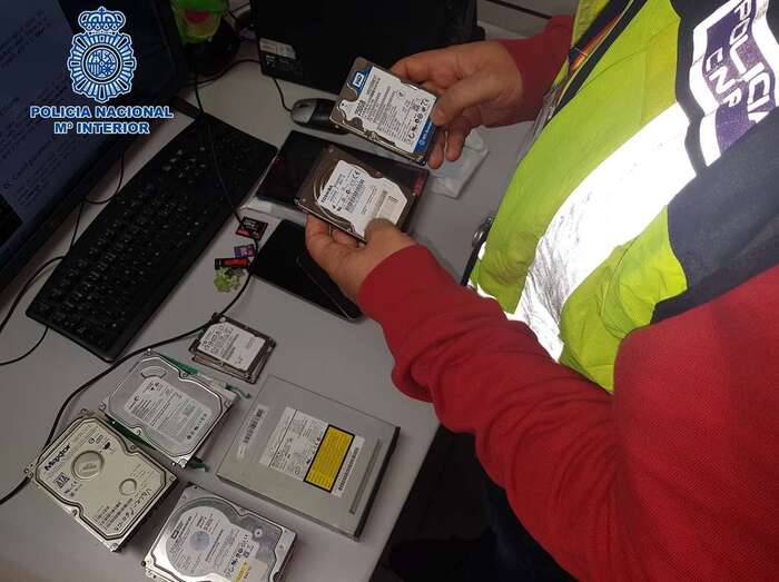 Agente de la Policía Nacional con el material pornográfico (Foto TA)