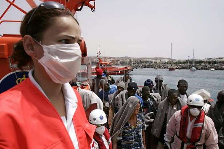 Imagen de archivo de un miembro de la Cruz Roja esperando inmigrantes de la patera localizada al sur de Gran Canaria desembacados en el muelle de Arguineguín, donde los trasladó una embarcación de Salvamento Marítimo (Foto Efe /Ángel Medina G.)