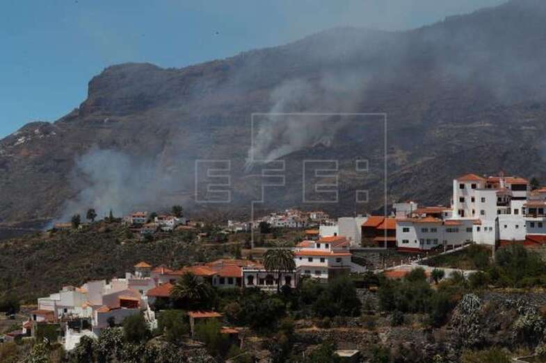 Vista del pueblo de Tejeda y detrás uno de los focos del incendio que afecta desde el sábado a la cumbre de Gran Canaria (Foto Efe / Elvira Urquijo A.)