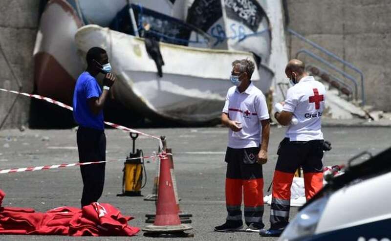 Imagen de un inmigrante con miembros de Cruz Roja en Arguineguín (Foto Arcadio Suárez/C7)
