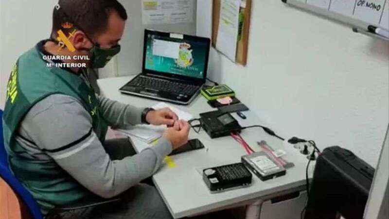 Agente de la Guardia Civil inspeccionando los dispositivos requisados al detenido/Guardia Civil.