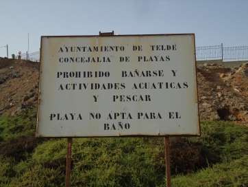 Cartel que prohíbe el baño en la zona donde se producen los vertidos de aguas fecales en Bocabarranco (Foto TA)