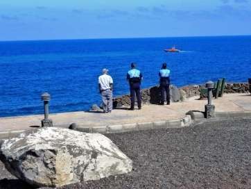 Agentes de la Policía Local y una embarcación de Salvamento Marítimo observando ayer la mancha (Foto TA)
