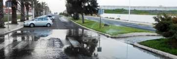 Charco formado en la carretera por el mal funcionamiento de los aspersores