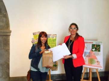 La concejala de Playas, María González Calderín (d), entrega los premios a una representante de los colegios premiados (Foto TA)