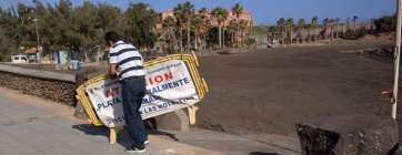 Momento en que se retira el balizamiento que prohibía el baño en Hoya del Pozo (Foto TA)
