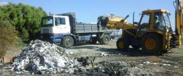 Un tractor y un camión, en las labores de limpieza del vertido (Foto TA)