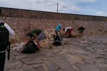 Basura y escombros acumulados en el canal del barranquillo de Ojos de Garza  y labores de limpieza acometidas este sábado por un grupo de teldenses (Foto TA)