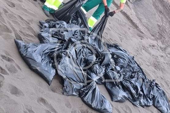 Operarios municipales retiran de Playa del Hombre el vertido residual que llegó a su orilla/TA.