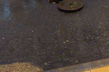 Tapa levantada de la red de alcantarillo en la calle de Alfambra en Hoya Aguedita/TA.