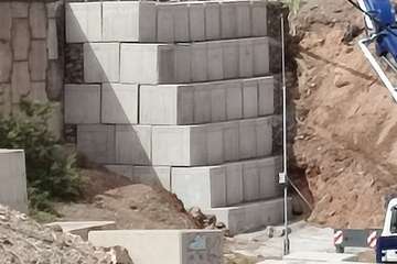 Obras de construcción de muro de contención de hormigón armado/TA.