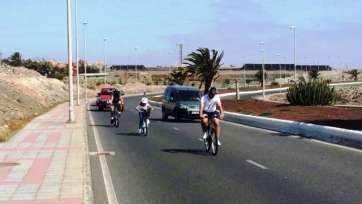Participantes de la Fiesta con vehículos detrás por no haberse cortado la circulación (Foto TA)