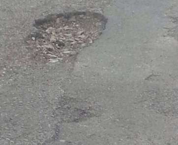 Uno de los socavones de la carretera aledaña al colegio Príncipe de Asturias de Melenara (Foto TA)