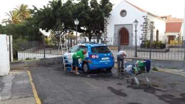 Gorrillas en plena limpieza de un coche policial en la vía pública, el pasado sábado en San Juan (Foto TA)