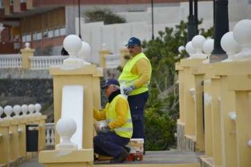 Operarios pintan la balaustrada del paseo marítimo en Taliarte (Foto TA)
