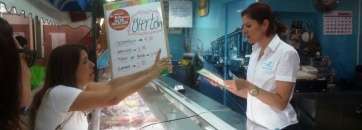 Carmen Hernández explica su proyecto a una puestera del Mercado Municipal (Foto TA)