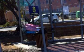 Persona que duerme en la parada de guaguas (Foto TA)