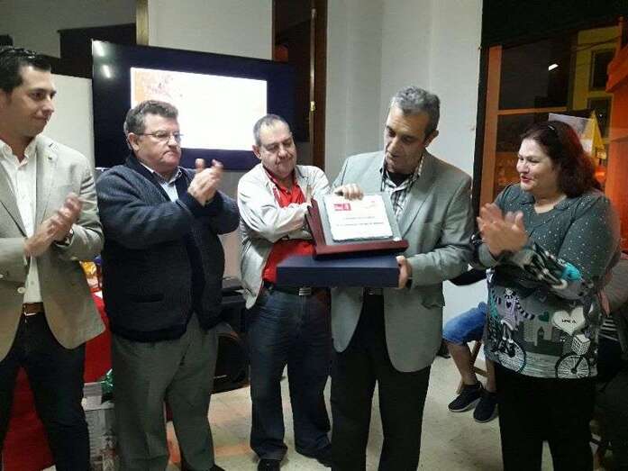 Ricardo Castillo observa la placa de reconocimiento que se le entregó esta noche (Foto TA)
