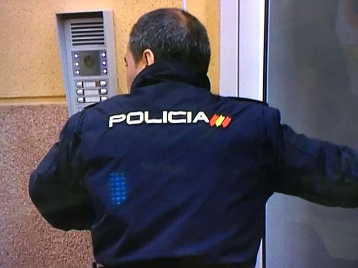 Un policía nacional en la puerta del edificio donde ocurrió el suceso (Imagen captada por TA de Televisión Canaria)