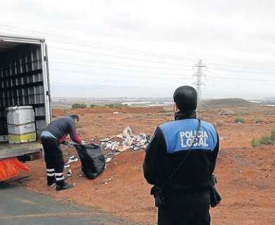  Un policía local observa mientras una de las empresas retira el vertido entre Piletillas y Ojos de Garza (Foto C7)