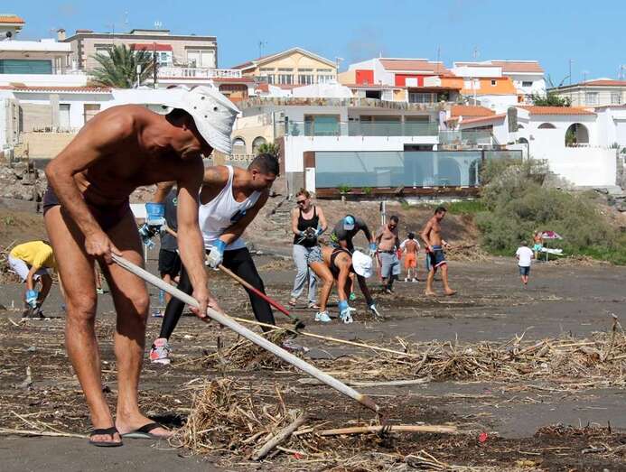 Ardhvio. Vecinos limpian una playa de Telde después de las lluvias torrenciales de octubre de 2015 (Foto TA)