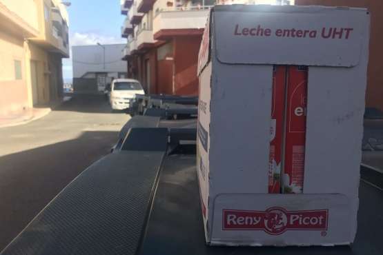 Caja de botes de leche sobre una tapa de un contenedor en una calle de Jinámar (Foto TA)