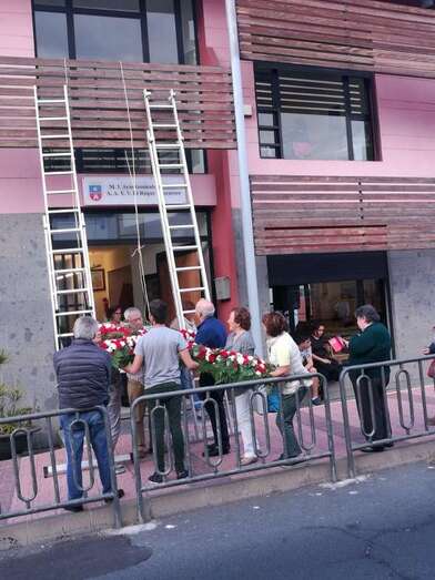 Colocación de un cruz de flores en el frontis del local vecinal de El Roque Azucarero (Foto TA)