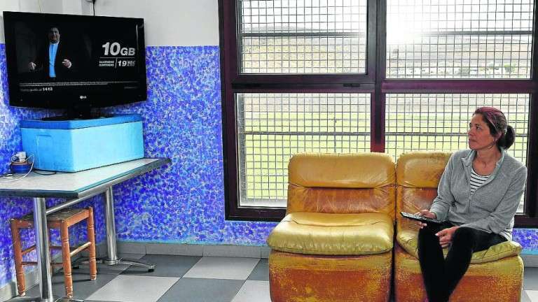 Loli Chirino, en la parte del local donde vive que más se parece a una casa. En esta misma sala duerme. Su hijo lo hace en la oficina. Al fondo, el campo (Foto Juan Carlos Alonso/C7)