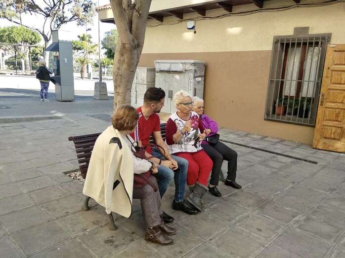 El portavoz de Ciuca, Juan Antonio Peña, sentando junto un grupo de usuarias del Centro de Mayores (Foto TA)