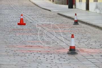Conos indicando las piezas repuestas en el adoquinado de la calle principal de San Juan (Foto TA)