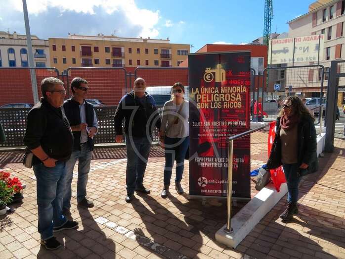 Miembros de Anticapitalistas junto al desplegable en el Mercado provisional de Narea (Foto TA)