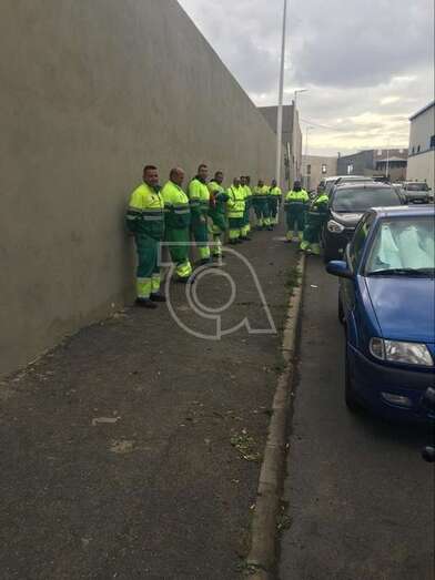El personal que no salió a trabajar junto a la nave de la empresa concesionaria en el Parque Empresarial de Melenara (Foto TA)