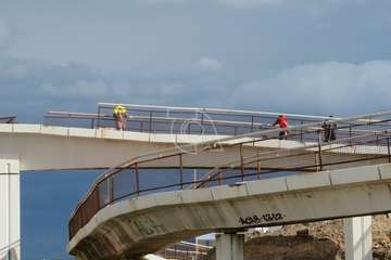 Operarios municipales retiran las vallas oxidadas de un paso elevado del vial costero de Telde/TA.