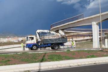Operarios municipales retiran las vallas oxidadas de un paso elevado del vial costero de Telde/TA.