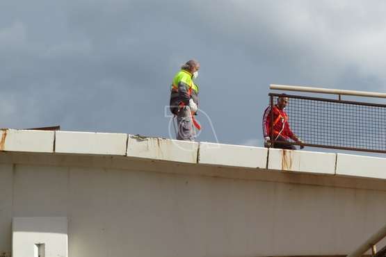 Operarios municipales retiran las vallas oxidadas de un paso elevado del vial costero de Telde/TA.