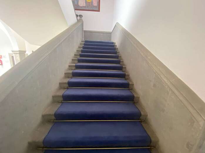 Alfombra azul repuesta en la escalinata de acceso a la segunda planta del edificio/TA.
