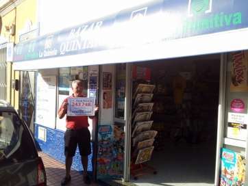 El propietario del bazar con el cartel que acredita el premio (Foto TA)