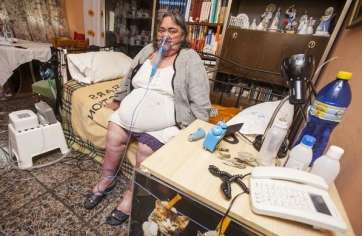 Pino Cabrera, postrada en la cama de su piso situado en la planta 11 de un bloque de Jinámar (Foto Borja Suárez-C7)