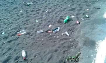 Residuos en la arena este domingo tras la celebración el sábado de la romería del barrio (Foto TA)