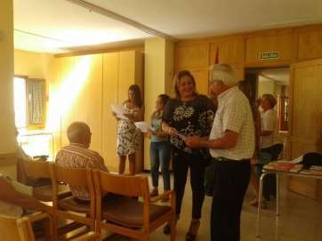 La alcaldesa conversa con uno de los mayores que viajarán a la Península (Foto TA)