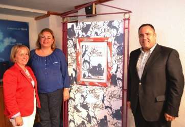 La alcaldesa, concejala y directora del Colegio Salesiano de Telde, delante del cartel de las fiestas (Foto TA)